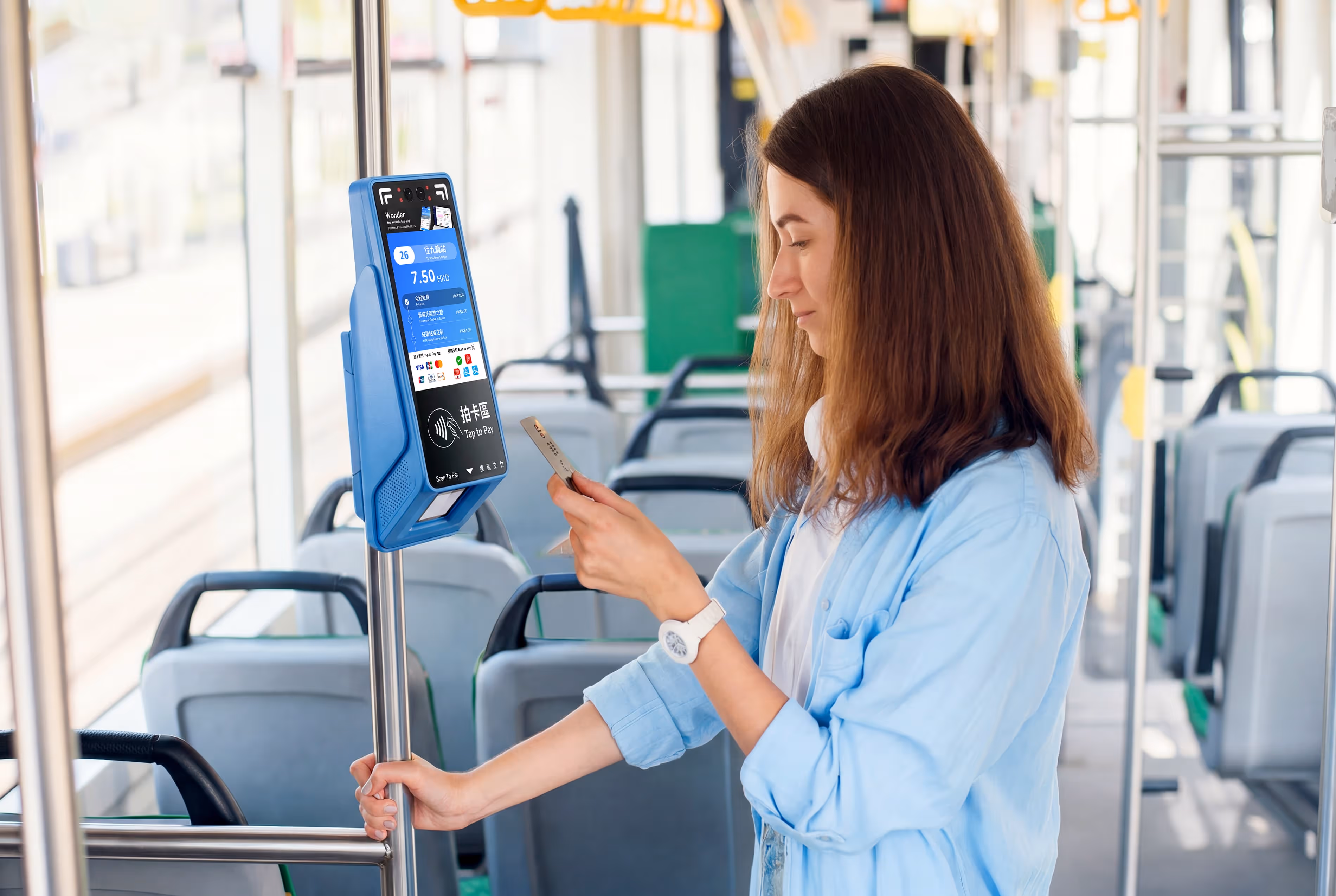 Passenger tapping to pay a fare on a Wonder Transit X validator on board a bus